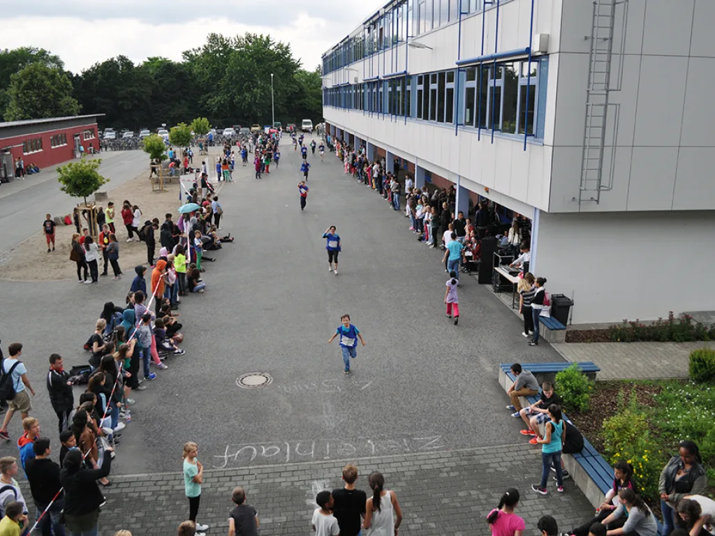 Blick über den Schulhof mit mehreren Läufern.
